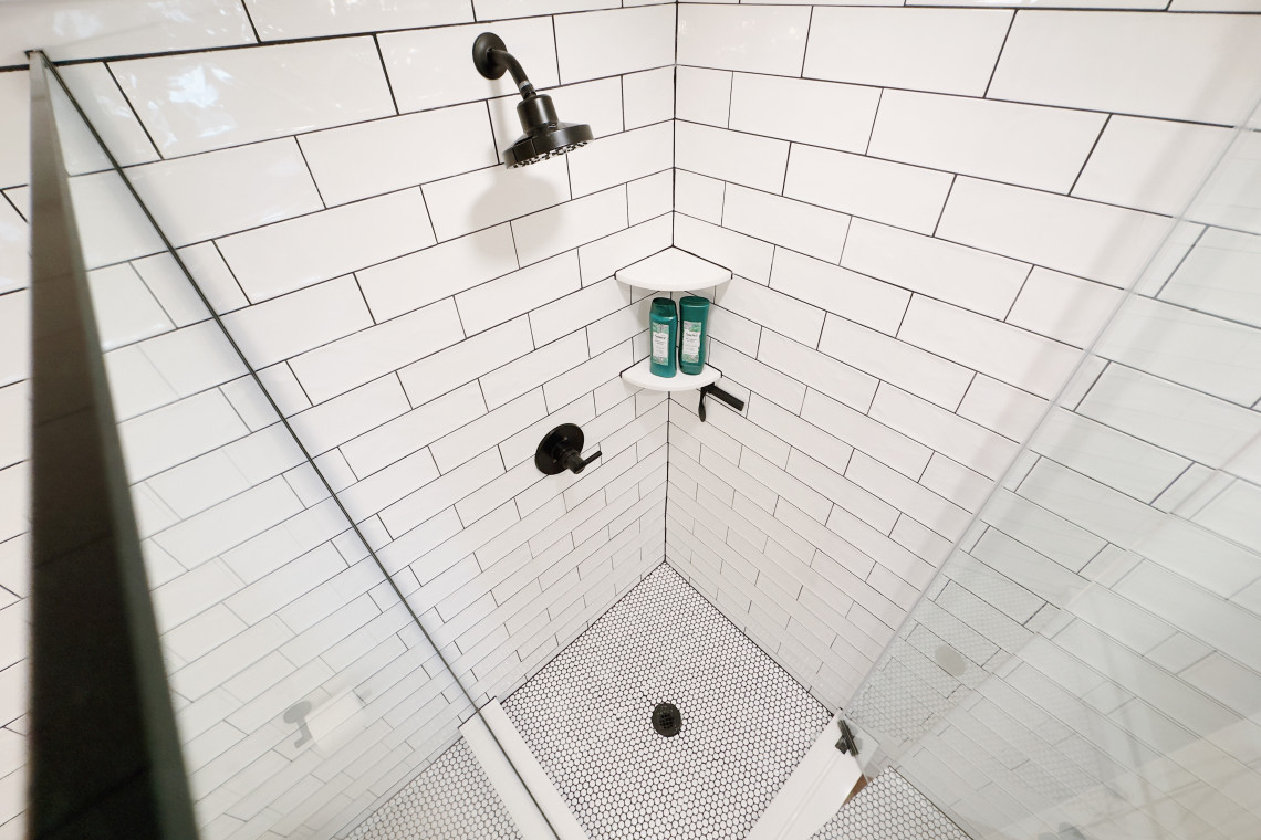 The modern clean shower with its sleek lines, frameless glass walls, and black stainless fixtures exudes a sense of sophistication and provides a refreshing and invigorating start to the day